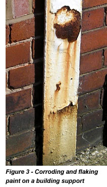 Corroding and flaking paint on a building support